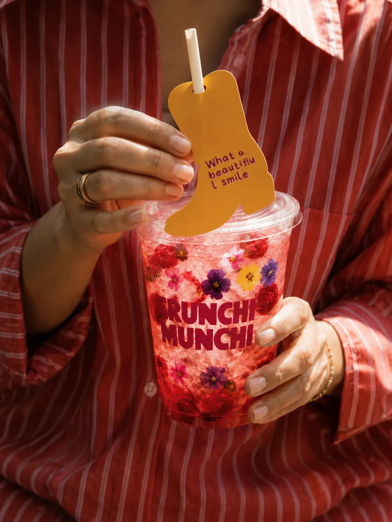 Iced lemonade with edible flowers held in two hands